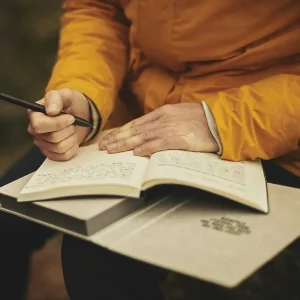 Person schreibt in Buch