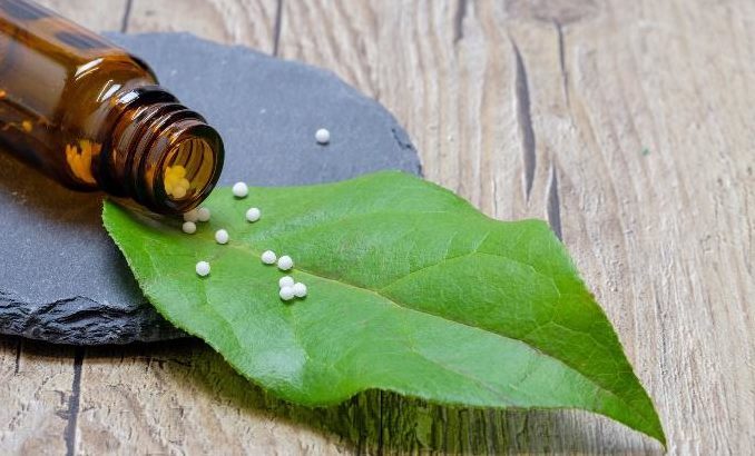 Homöopathische Globuli mit grünem Blatt