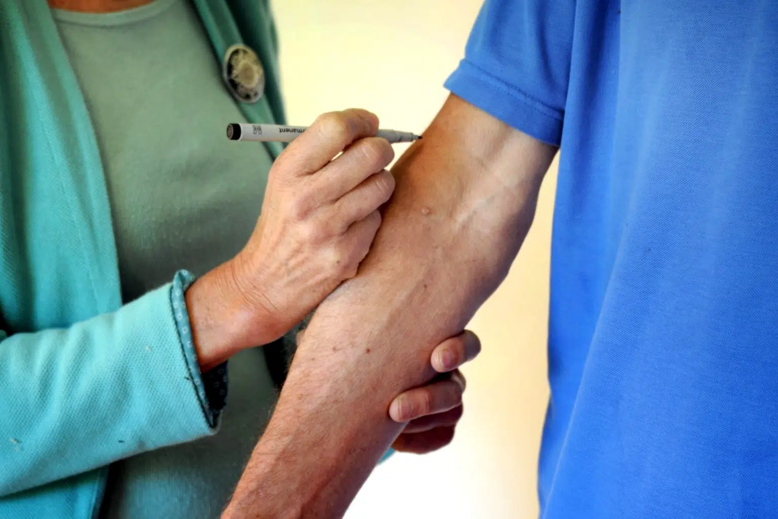 2 Personen und ein Arm auf den etwas gemalt wird