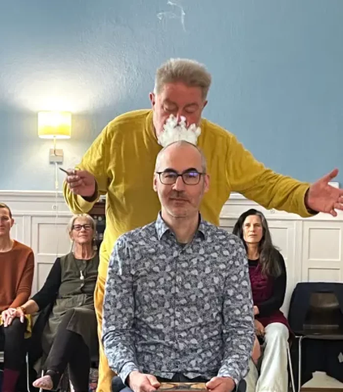 Andreas bläst Rauch auf den Kopf eines Klienten