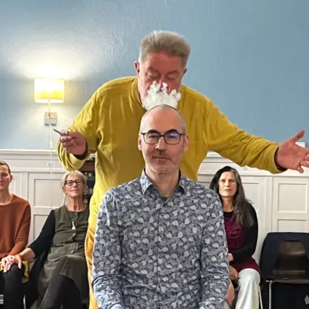 Andreas bläst Rauch auf den Kopf eines Klienten